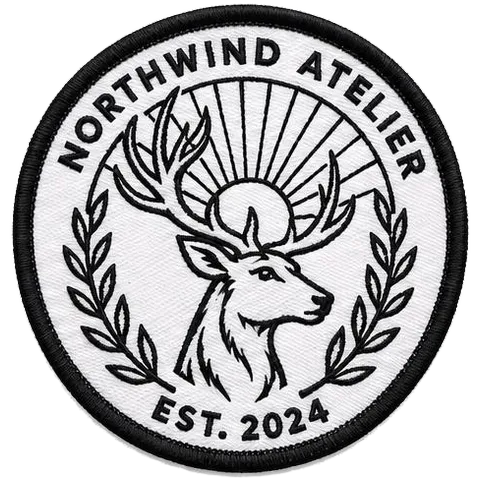 Circular Northwind Atelier patch embroidered in black thread with light 50% coverage on white twill
